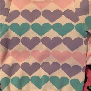 White sweater with colourful hearts.